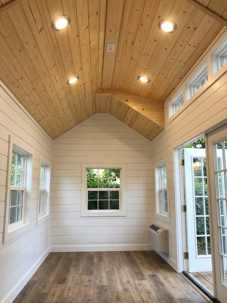 Gold interior with white shiplap walls, vaulted pine ceiling, recessed lights and French doors