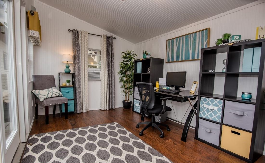 Finished backyard studio office with reading chair, desk and window