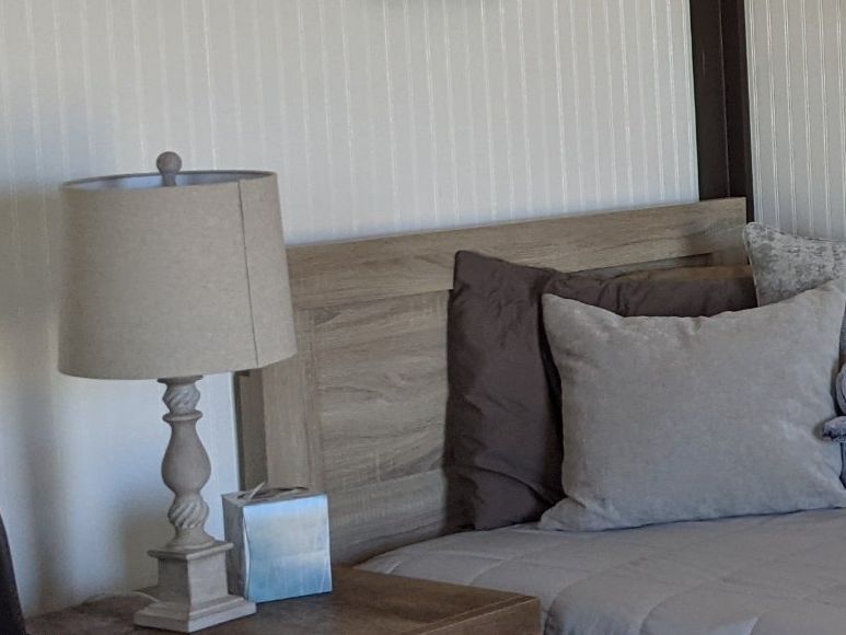 Finished studio set up as a guest room with bed and lamp