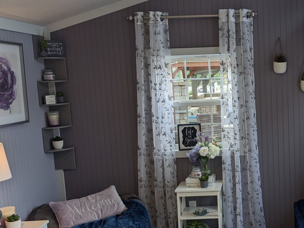 Finished studio set up as a cozy reading nook with curtains and bench